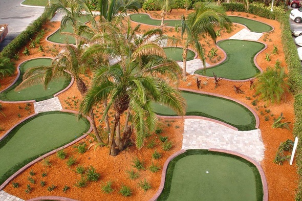 Metro New York Aerial view of a mini golf course with synthetic grass and palm trees.